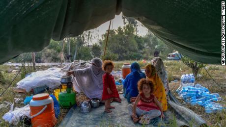 Displaced people prepare for breakfast in their tents at a makeshift camp after fleeing from their flood-hit homes following heavy monsoon rains in Charsadda district of Khyber Pakhtunkhwa on August 29, 2022.