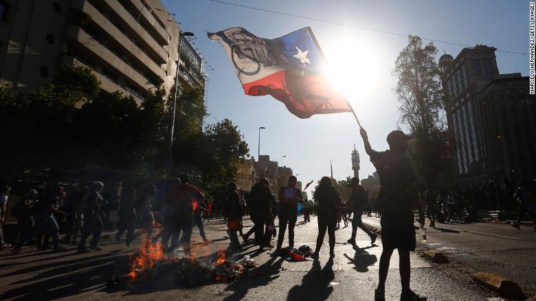 A demonstrator waves the Chilean flag during a November 2020 protest against then President Sebastian Pinera in Santiago.
