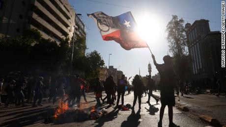 A demonstrator waves the Chilean flag during a November 2020 protest against then President Sebastian Pinera in Santiago.

