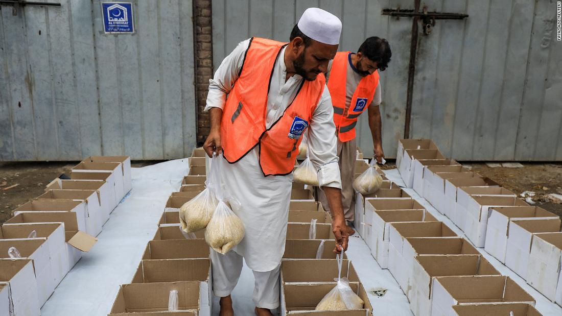 Volunteers prepare food boxes to distribute among flood victims in Peshawar on Friday, August 26.