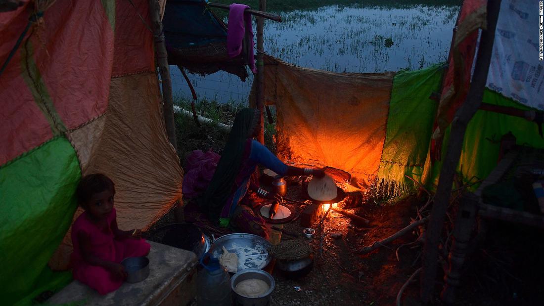 A woman cooks food for her flood-affected family at a makeshift camp in Nawabshah, Pakistan, on Thursday, August 25.
