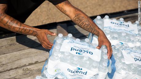 Malcolm Pickett lifts a case of water outside of New Jerusalem Church in Jackson, Mississippi, on August 31.