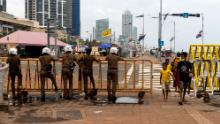 A police officer stands behind a security barricade near a protest camp in Colombo, Sri Lanka on August 5, 2022
