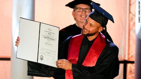 Stephen Curry poses with his diploma after his graduation ceremony at Davidson College.
