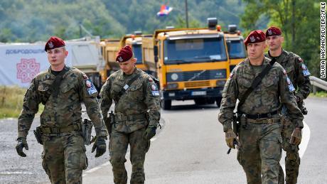 جنود بولنديون في مهمة حفظ سلام تابعة لحلف شمال الأطلسي في كوسوفو يسيرون عبر حاجز بالقرب من المعبر الحدودي بين كوسوفو وصربيا في 28 سبتمبر 2021.