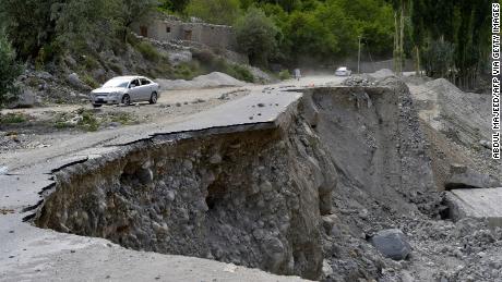 Um veículo passa por uma seção parcialmente desmoronada da rodovia Karakoram, no Paquistão, danificada após a erupção de um lago glacial na região de Gilgit-Baltistão.