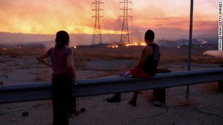 Residents who were evacuated from their home watch as the Route Fire burns on August 31, 2022 near Castaic, California. 