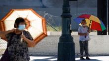 Mandatory Credit: Photo by CAROLINE BREHMAN/EPA-EFE/Shutterstock (13359172p) People walk with umbrellas for shade in Los Angeles, California, USA, 01 September 2022. The National Weather Service has issued an excessive heat warning for much of Southern California as temperatures are expected to hit triple digits this week, lasting at least through Monday evening. Temperatures in some areas are predicted to either match or break previous records. Heat wave hits Southern California, Los Angeles, USA - 01 Sep 2022
