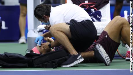 Nadal receives medical attention after accidentally hitting himself in the head with his racquet.