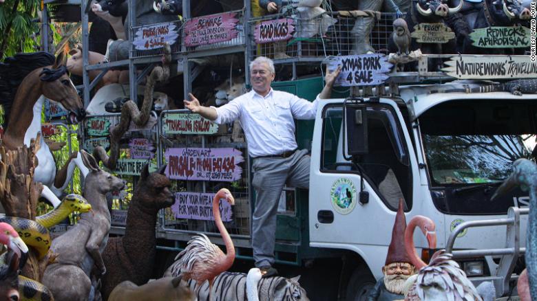 David Joffe poses for pictures near the animal sculptures that he sells worldwide.  