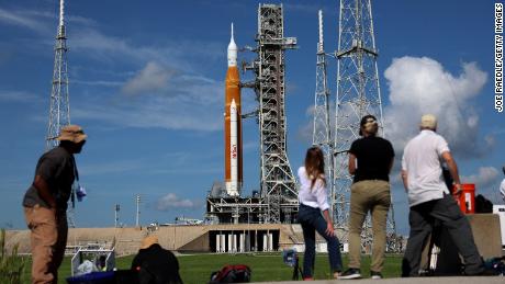 Fotografi e giornalisti lavorano lunedì vicino al razzo Artemis I della NASA al Kennedy Space Center.  Una serie di problemi in seguito ha impedito all'aereo di decollare.