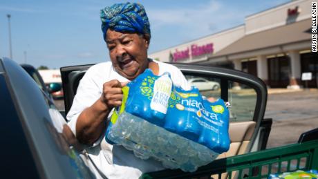 Glenda Johnson places bottled water she purchased at Grocery Depot into her car in Jackson, Mississippi, on August 31.