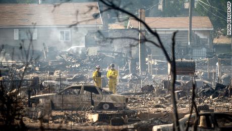 Firefighters survey homes  on Saturday destroyed by the Mill Fire in Weed, California.