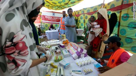 Yerinden edilmiş aileler, 4 Eylül 2022'de Pakistan'ın Sukkur kentindeki bir dağıtım noktasında ilaç almak için bekliyorlar.
