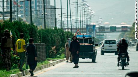 Taliban fighters (C) stand guard along a road near the Russian embassy after the attack on Monday. 