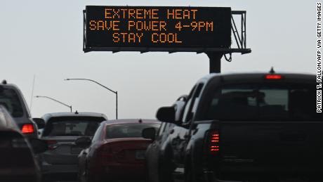 Vehicles drive Friday past a sign on the 110 Freeway warning of extreme heat and urging energy conservation during a heat wave in downtown Los Angeles.