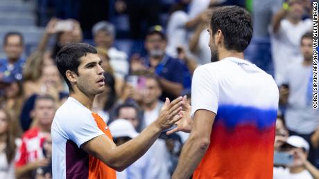 Alcaraz (left) and Cilic (right) shake hands after Tuesday's US Open match.