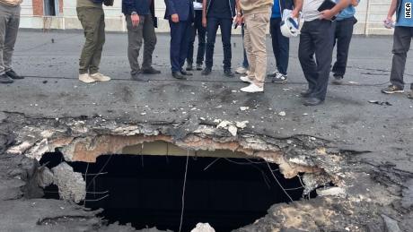 The IAEA team observes the damage caused by shelling on the roof of a building at Zaporizhzhia.