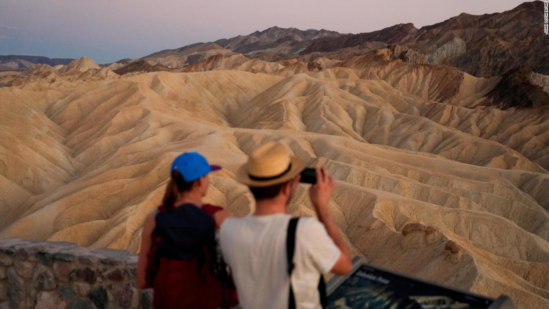 People visit Zabriskie Point in Death Valley National Park as the sun sets on September 1.