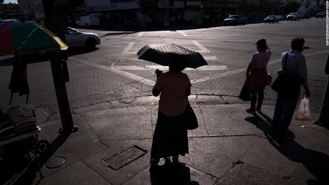 A pedestrian in Los Angeles uses an umbrella to block the sun on September 1.