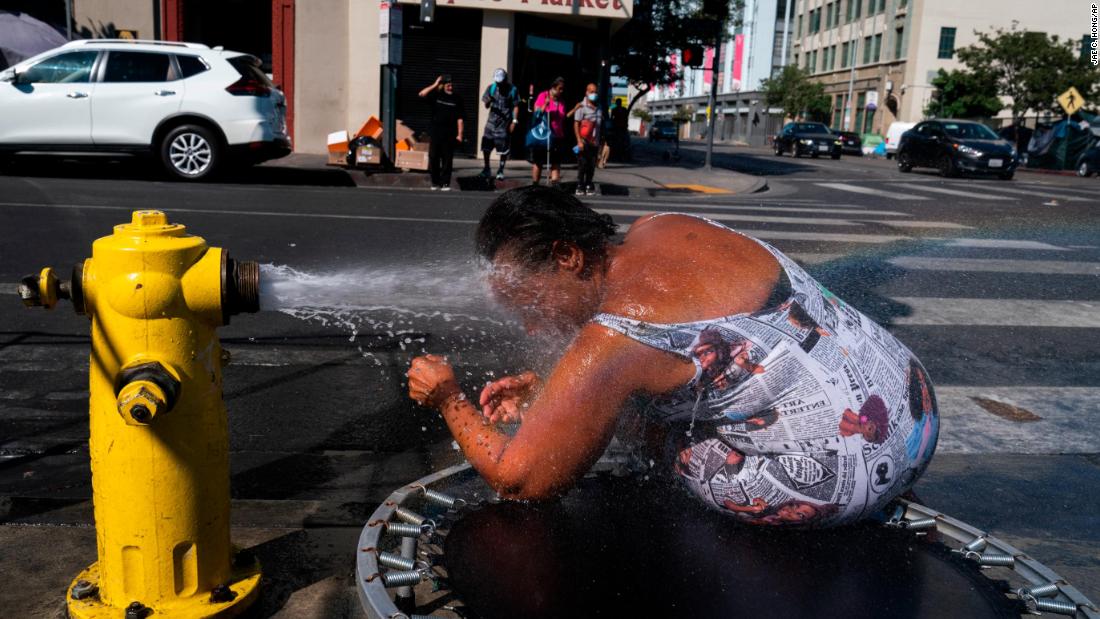 Stephanie Williams cools off at a fire hydrant in Los Angeles&#39; Skid Row neighborhood on August 31.