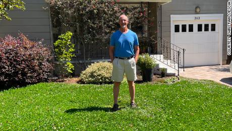 Christian Vescia on his front lawn -- where the grass has been replaced with a low-water ground cover. 