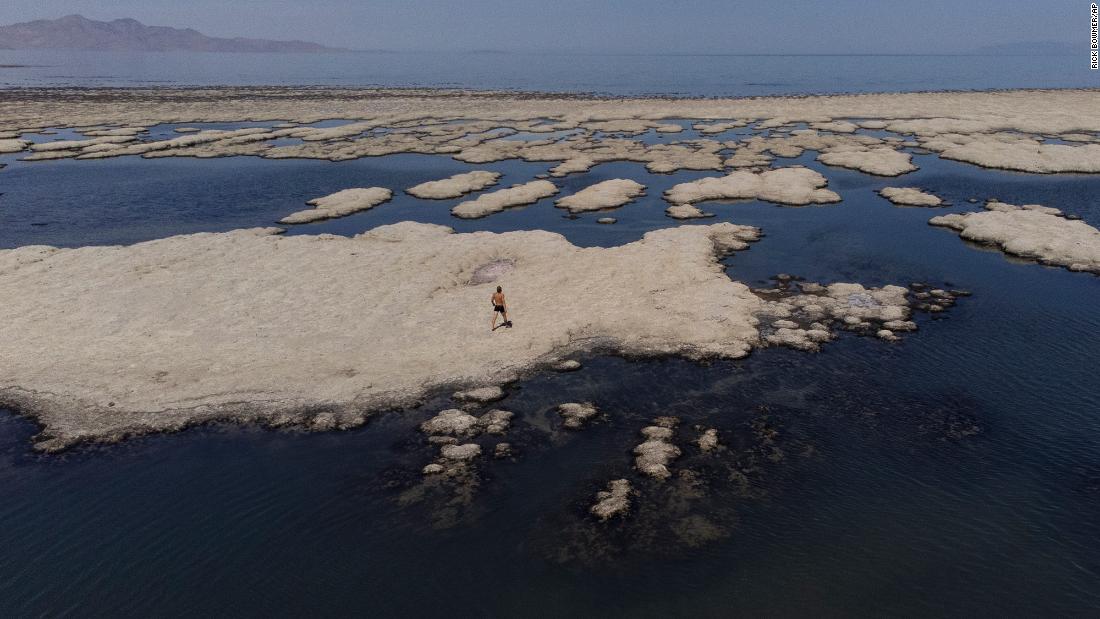 Olof Wood walks across reef-like structures exposed by receding waters at the Great Salt Lake in Salt Lake City on Tuesday, September 6. A blistering heat wave is breaking records in Utah, where temperatures in the capital hit 105 degrees Fahrenheit on Tuesday. That is the hottest September day on record in the city.