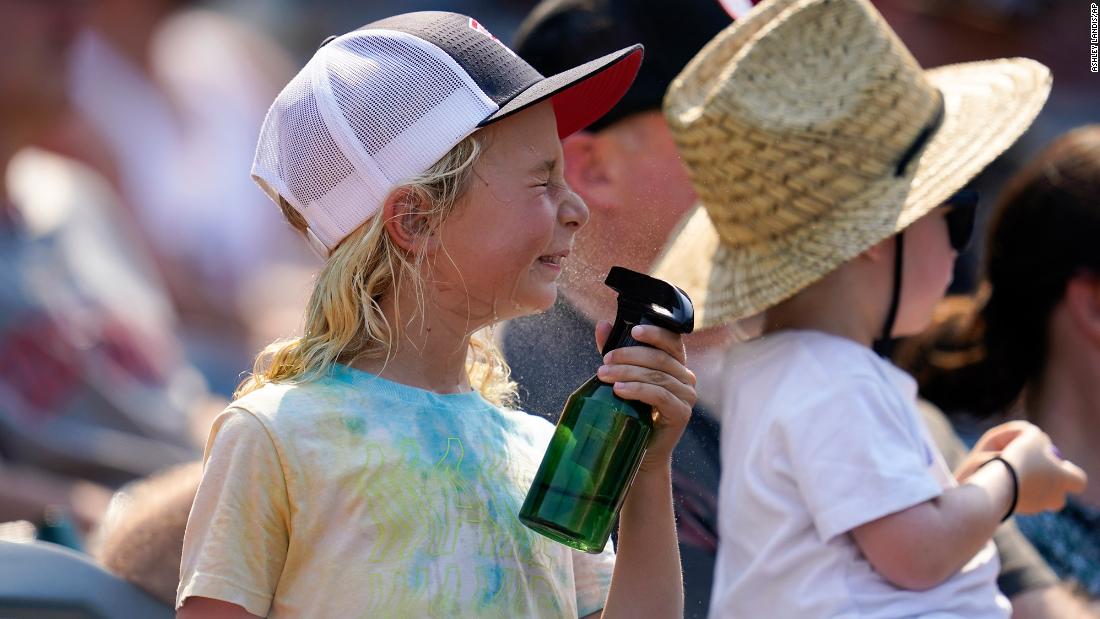 A girl sprays herself with water to cool off during a Los Angeles Angels baseball game against the Detroit Tigers in Anaheim, California, on Wednesday, September 7. The heat wave scorching California may be one of the worst on record for the state.