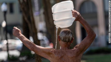 A resident cools down with a bottle of water in the scorching heat of Sacramento, Calif., on Tuesday.