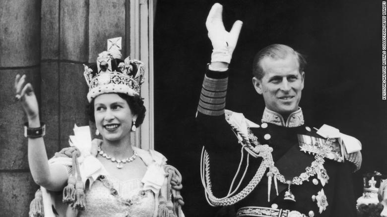 Queen Elizabeth II and the Duke of Edinburgh wave at the crowds from the balcony at Buckingham Palace after Elizabeth&#39;s coronation, on June 2, 1953. 