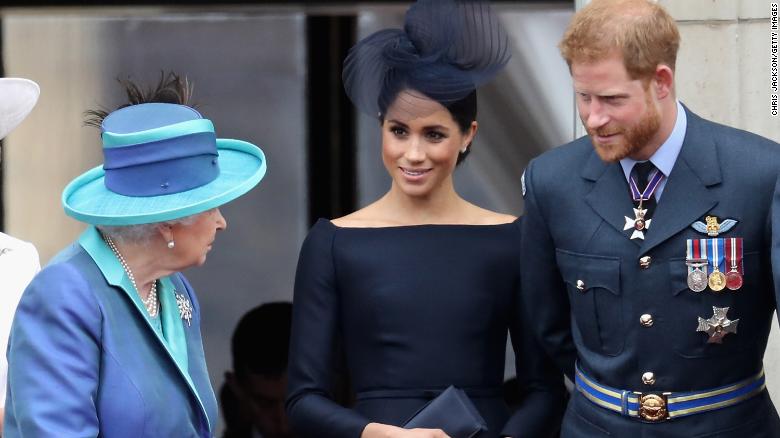 Queen Elizabeth II, Meghan, Duchess of Sussex, and Prince Harry watch a flypast on the balcony of Buckingham Palace as part of events to mark the centenary of the RAF on July 10, 2018 in London. 