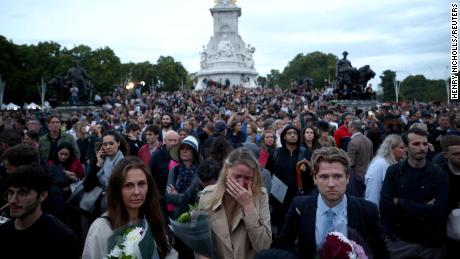People react outside the Buckingham Palace after the announcement of the death of the Queen.