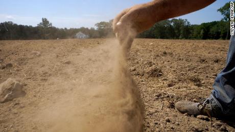 A farmer releases a handful of dry soil in Rhode Island in August. All of Massachusetts, Connecticut and Rhode Island are in drought.