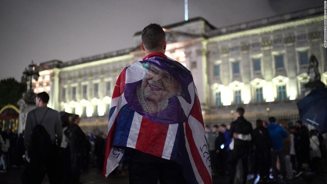 People pay their respects outside Buckingham Palace on Thursday.