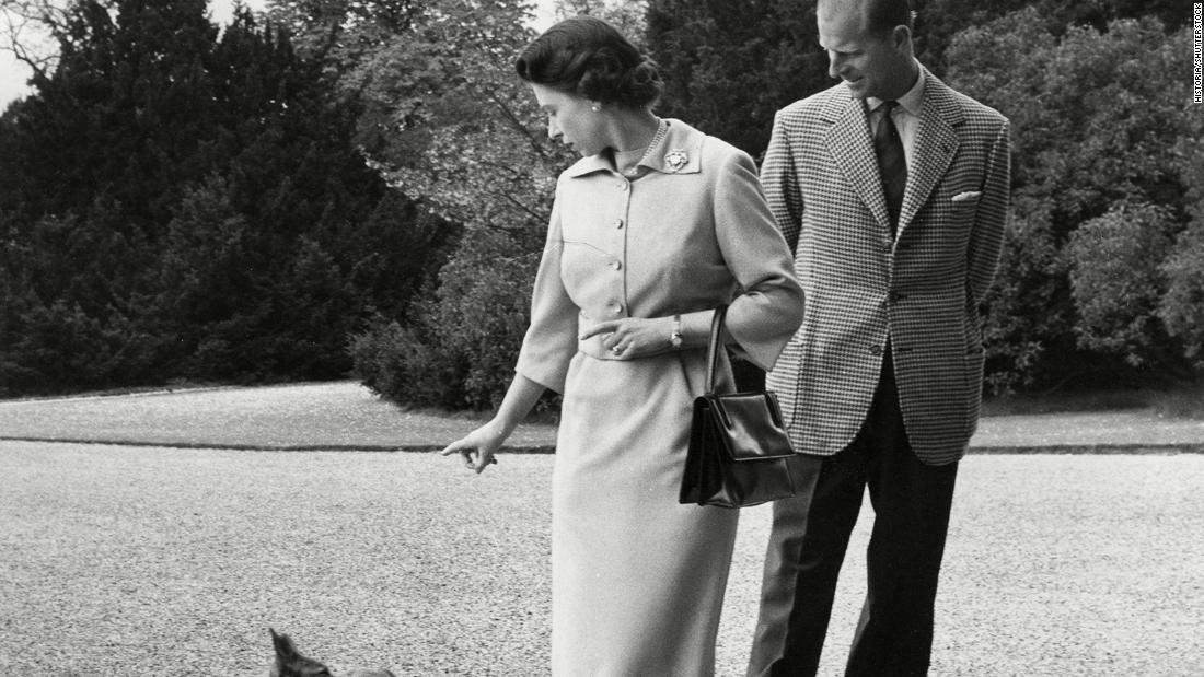 The Queen and Prince Philip watch her corgi Sugar outside Windsor Castle in 1959. 