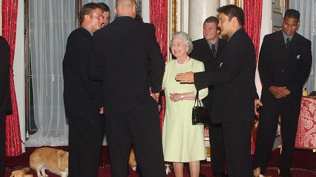 The Queen's dogs are all around her at Buckingham Palace as she meets the New Zealand rugby team in 2002.