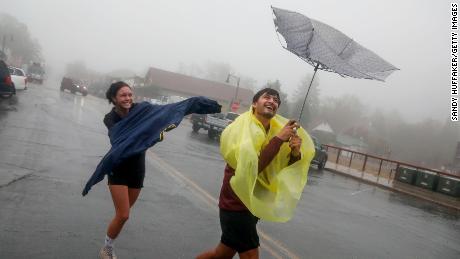 Carlos and Hailah Mierta walk as winds and rain fall on Thursday in Julian, California.