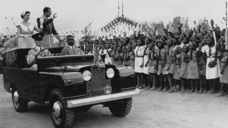 Queen Elizabeth II and Prince Philip wave to a crowd of schoolchildren at a rally held at a racecourse in Ibadan, Nigeria, February 15, 1956.