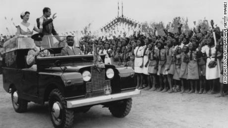 La regina Elisabetta II e il principe Filippo salutano una folla di scolari durante una manifestazione in un ippodromo a Ibadan, in Nigeria, il 15 febbraio 1956.