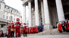 Honorary artillery spearmen and musketeers (left) stand outside the Royal Exchange in the City of London on Saturday before the reading of Charles III's coronation proclamation.