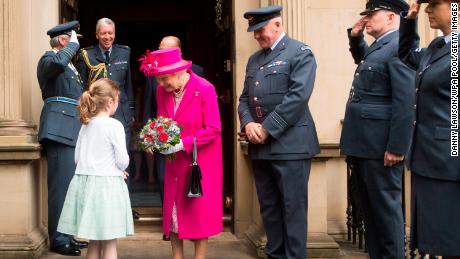 Queen Elizabeth II receives a posy of flowers from Charlotte Murphy during a visit to the headquarters of the Royal Auxiliary Air Force's 603 Squadron on July 4, 2015 in Edinburgh, Scotland.