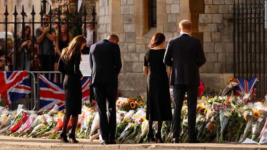 From left, Catherine, Prince William, Prince Harry and Meghan look at floral tributes outside Windsor Castle on September 10.
