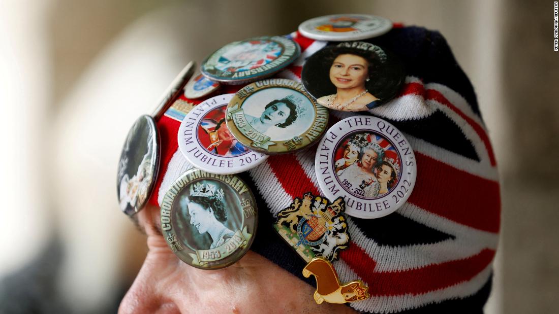A woman in London sports buttons with pictures of the Queen.