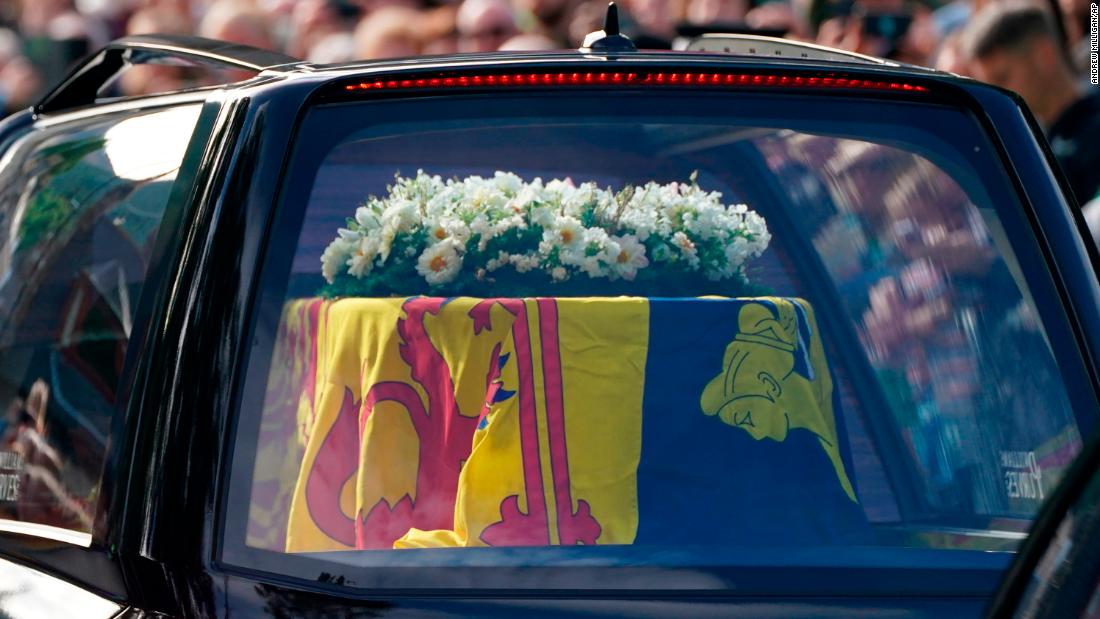The Queen&#39;s coffin is draped in the Royal Standard of Scotland and a wreath of flowers.