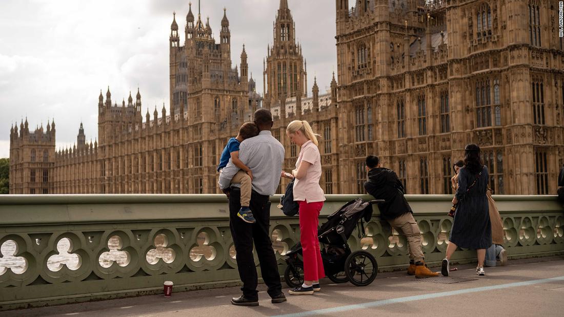 People look at the Palace of Westminster as a flag flies at half-staff on September 11.