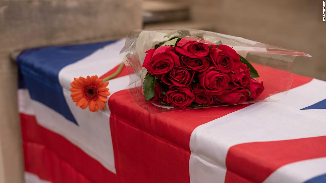 A bouquet of roses rests on a Union Jack flag in London.