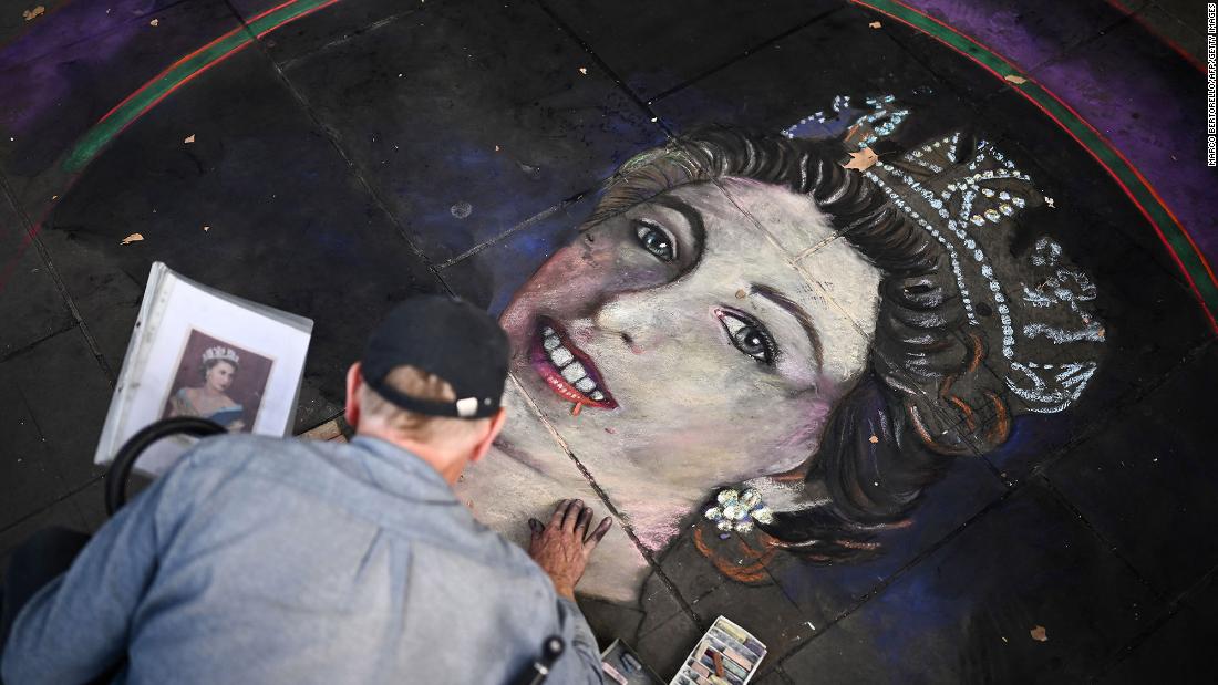 A chalk artist draws a portrait of the Queen at Trafalgar Square in London.