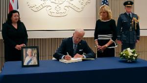 President Joe Biden signs a condolence book at the British Embassy in Washington, Thursday, Sept. 8, 2022, for Queen Elizabeth II, Britain&#39;s longest-reigning monarch and a rock of stability across much of a turbulent century, who died Thursday after 70 years on the throne. Charles Roxburgh, Permanent Secretary of HM Treasury of United Kingdom, left, British ambassador Karen Pierce, second from left, and first lady Jill Biden, second from right, look on. (AP Photo/Susan Walsh)