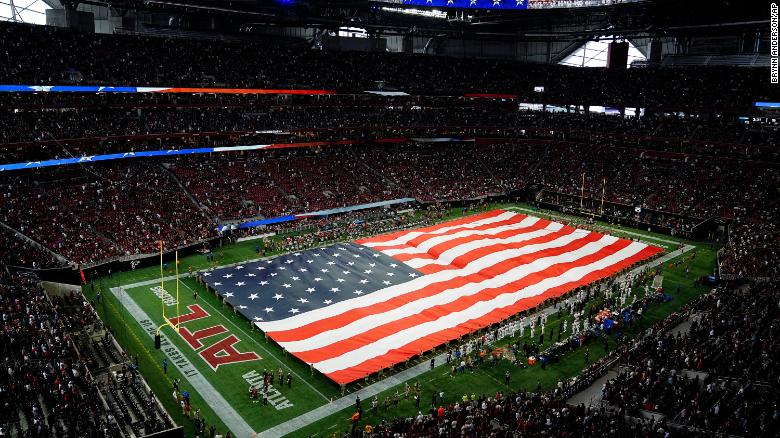 Soldiers hold the American flag during the national anthem before the first half of the game between the Atlanta Falcons and the New Orleans Saints on September 11 in Atlanta.