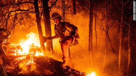 Firefighter Christian Mendoza lights a backfire to burn off vegetation on Tuesday. 